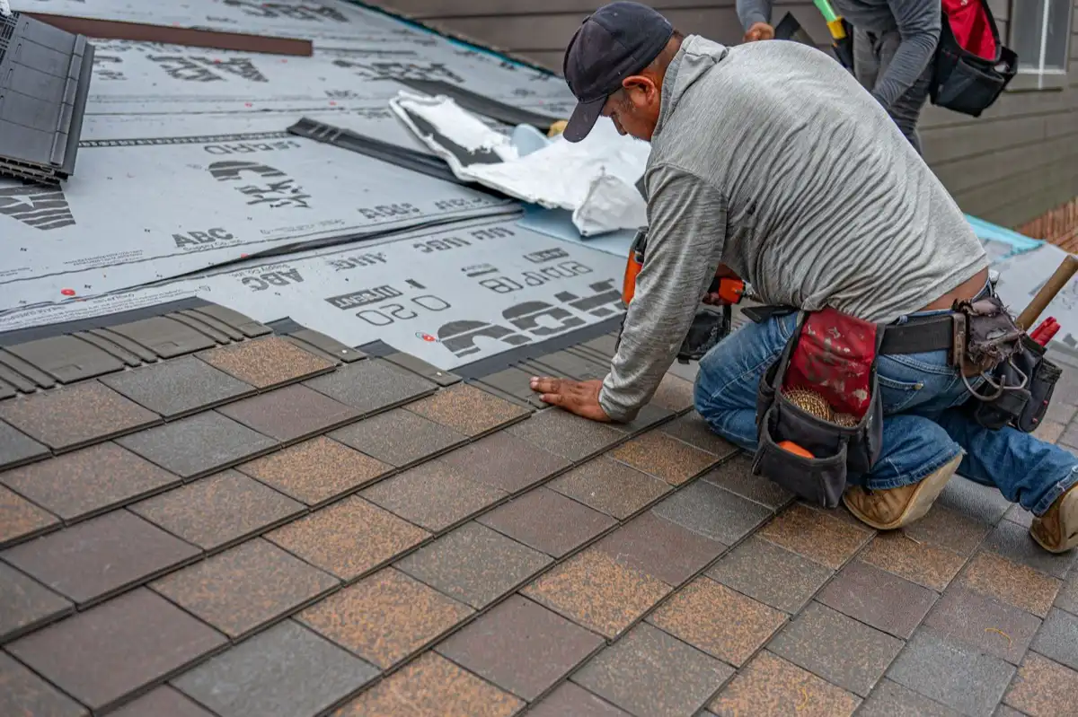 Roofing installer fastening shingles over new underlayment in Madison, WI
